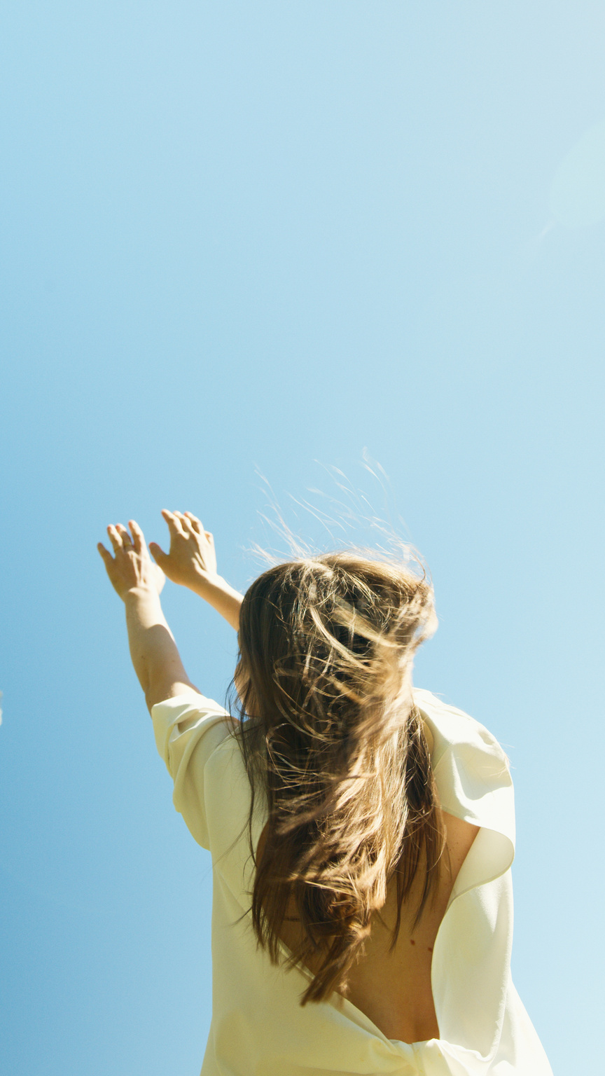 Back View of a Woman Raising Her Hands